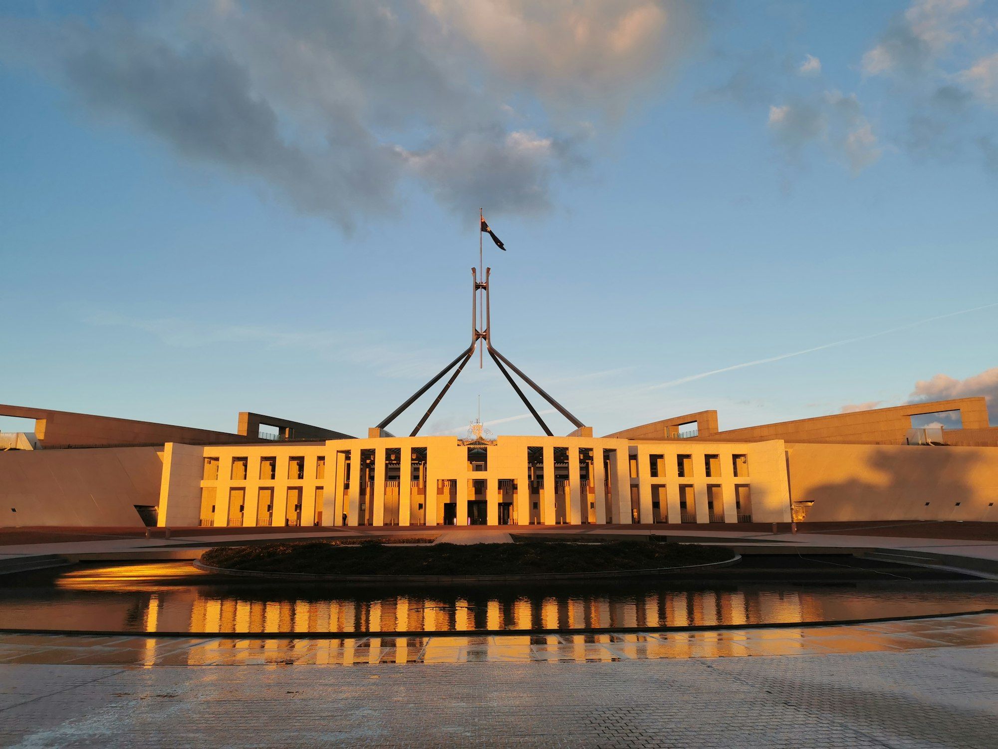 Australian Parliament House in Canberra with its flagpole on a clear day