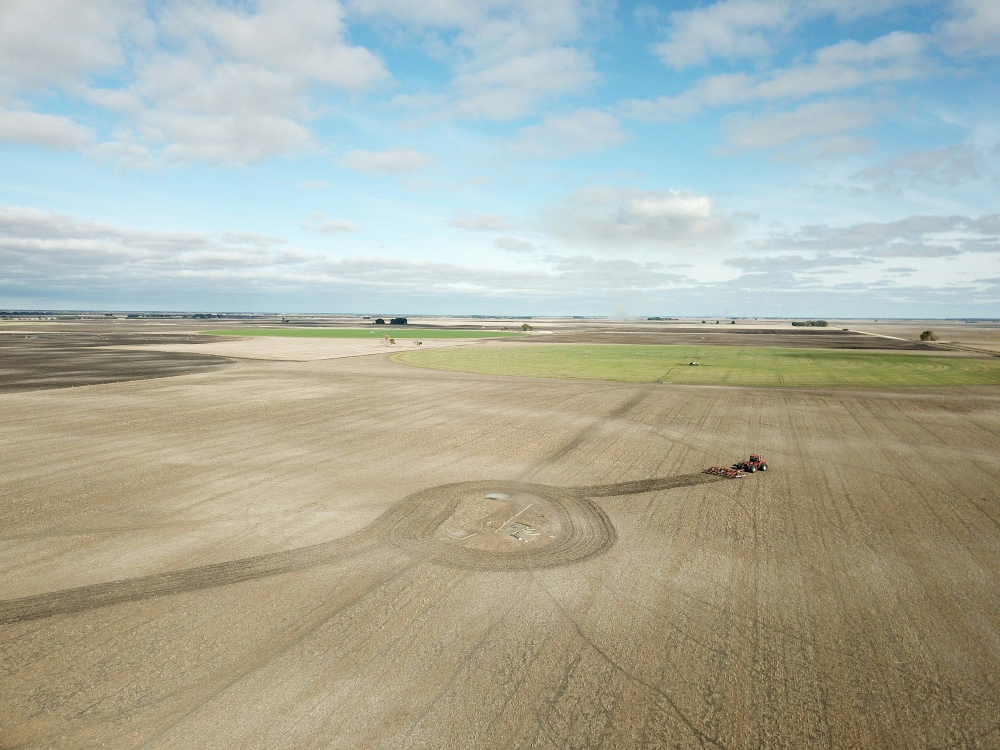 Tractor driving across a large open farm paddock near Adelaide, South Australia