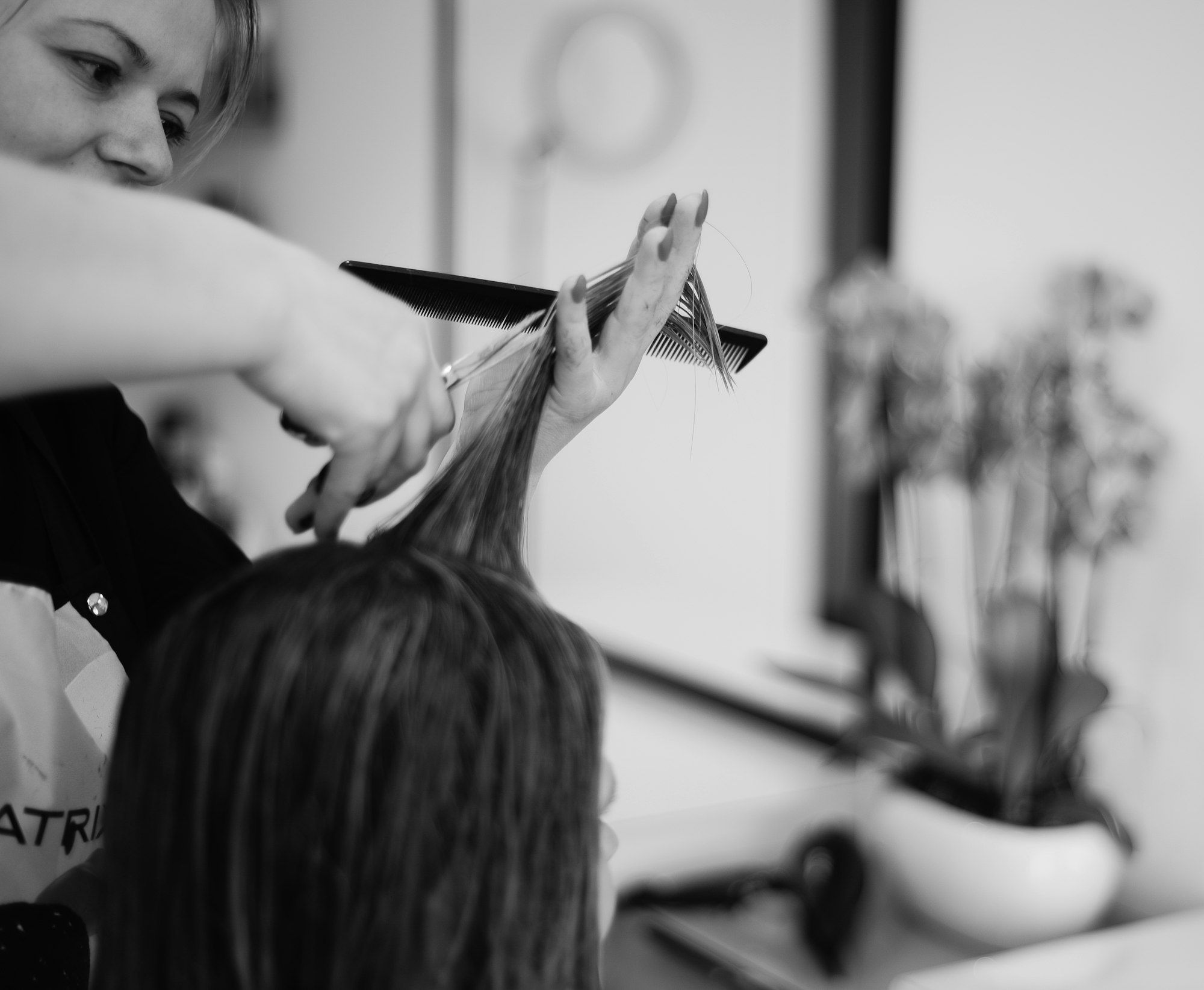 Hairdresser cutting a client's hair with scissors in a hair salon