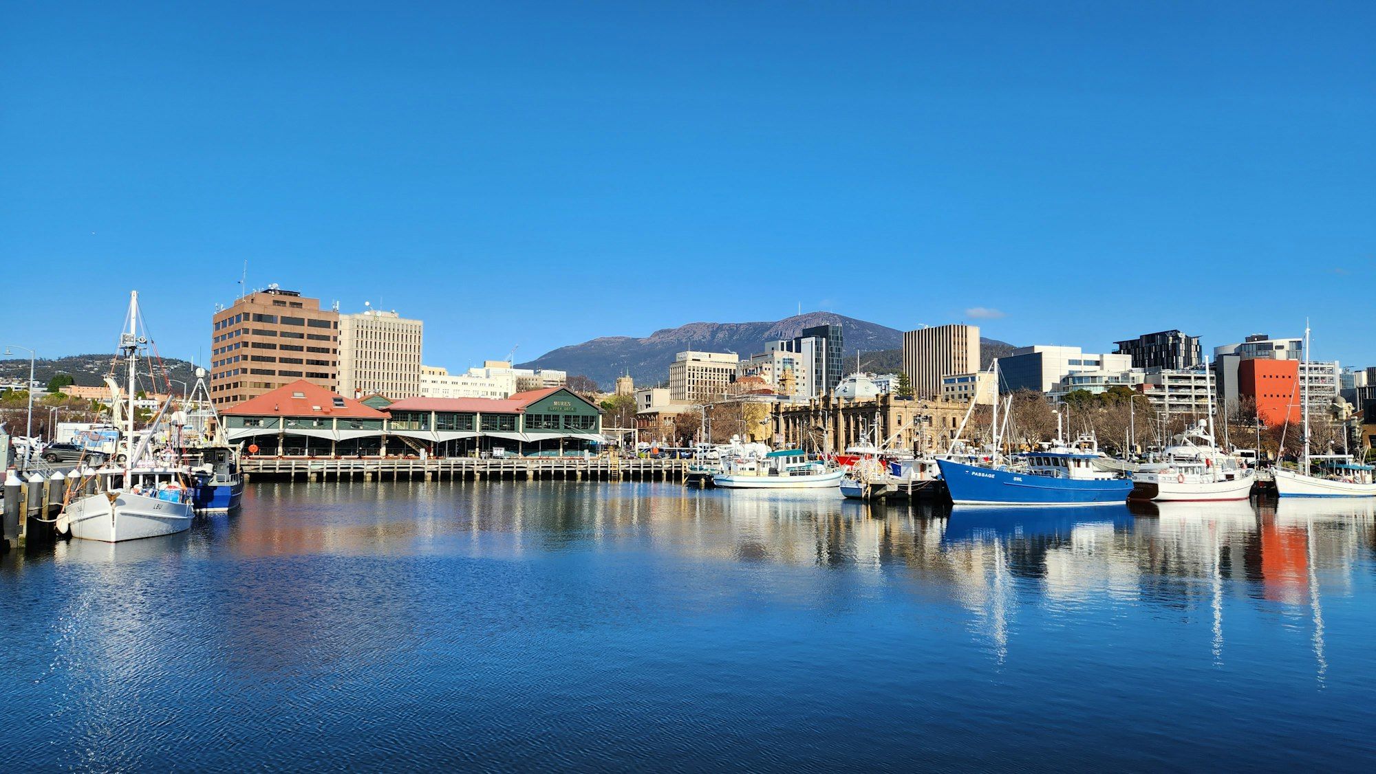 Boats moored in Hobart harbour in front of historic waterfront buildings