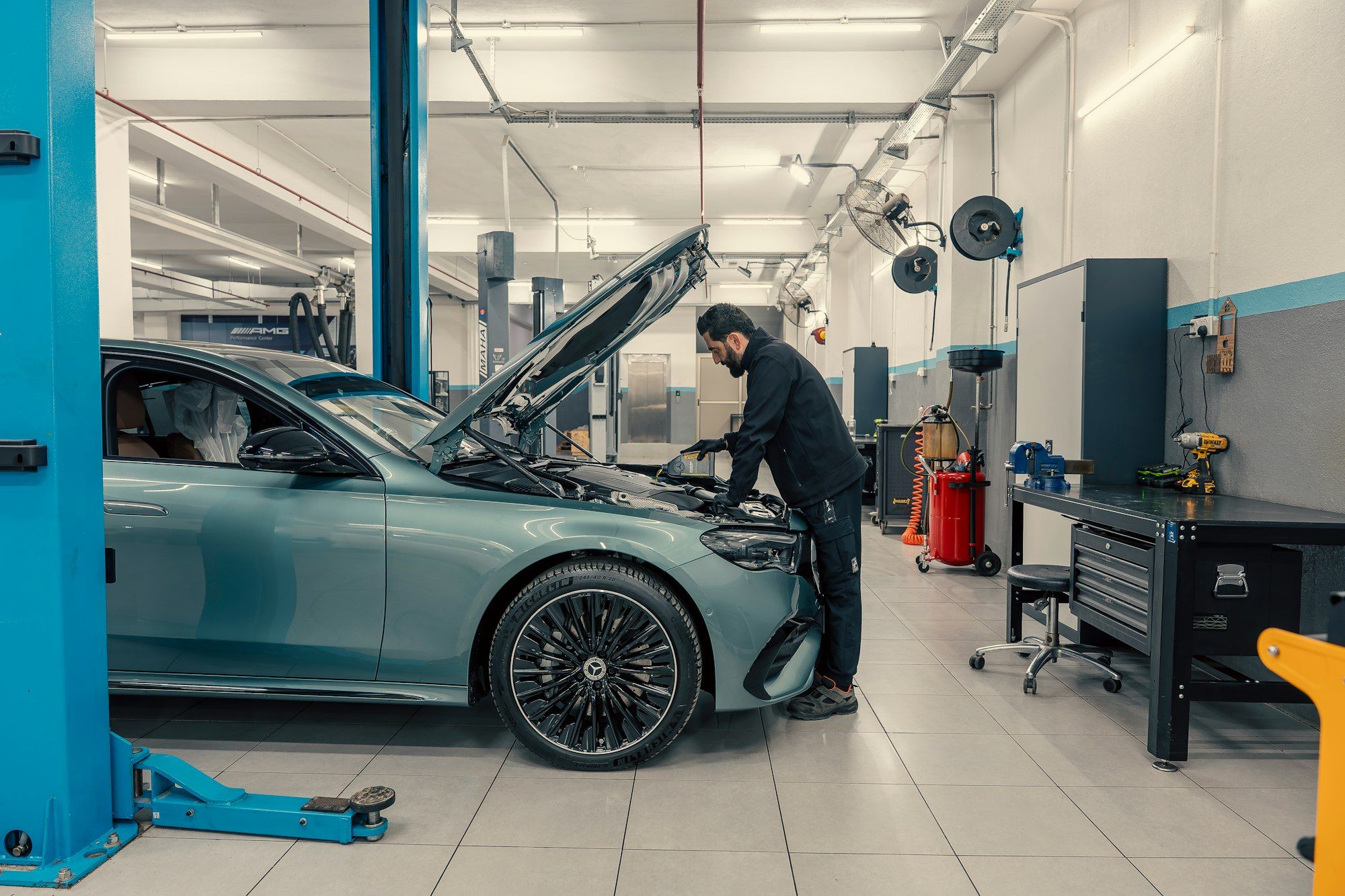 Mechanic working on a car engine inside an automotive repair workshop