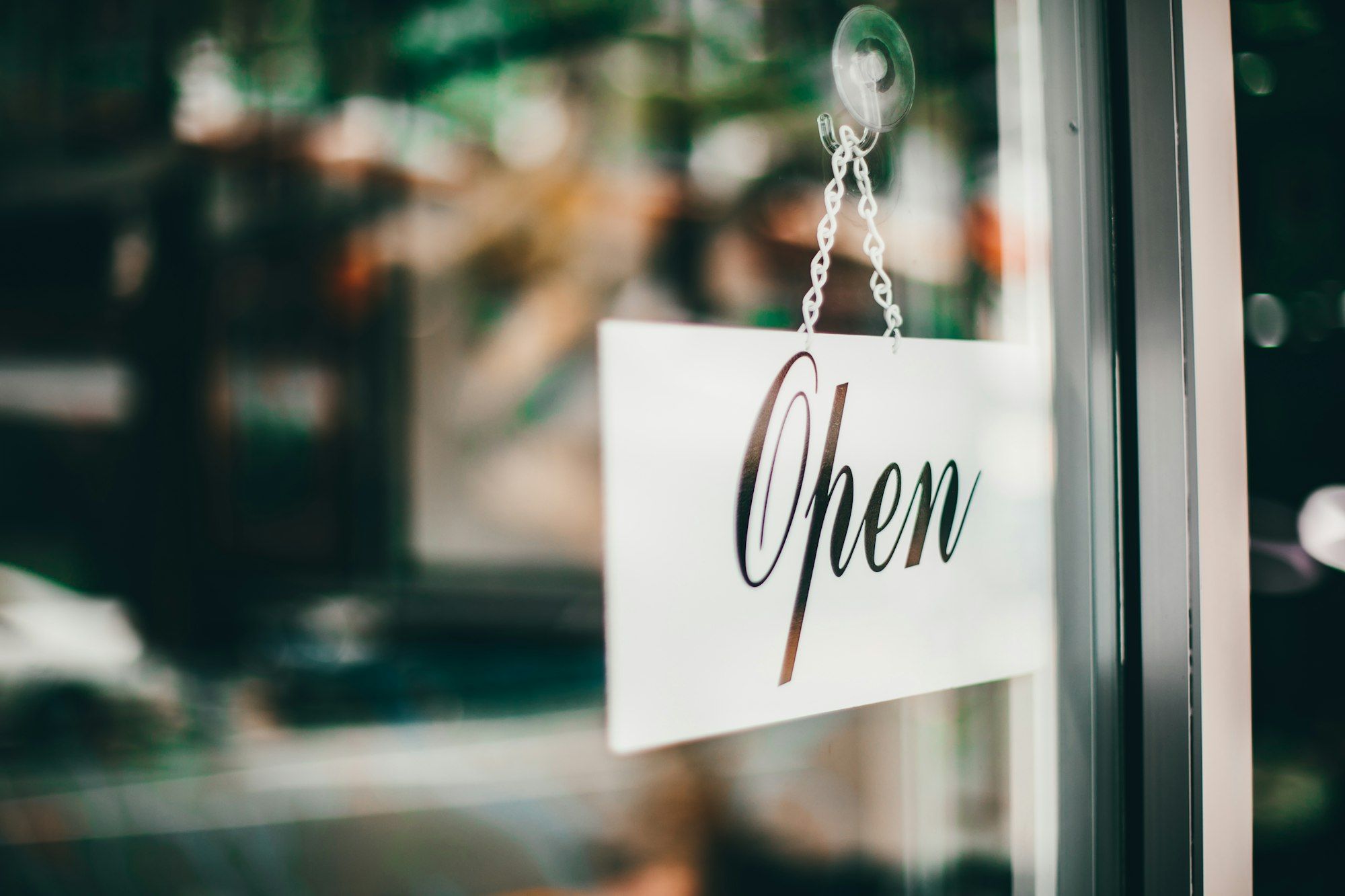 Open for business sign hanging in a shopfront window on the Gold Coast