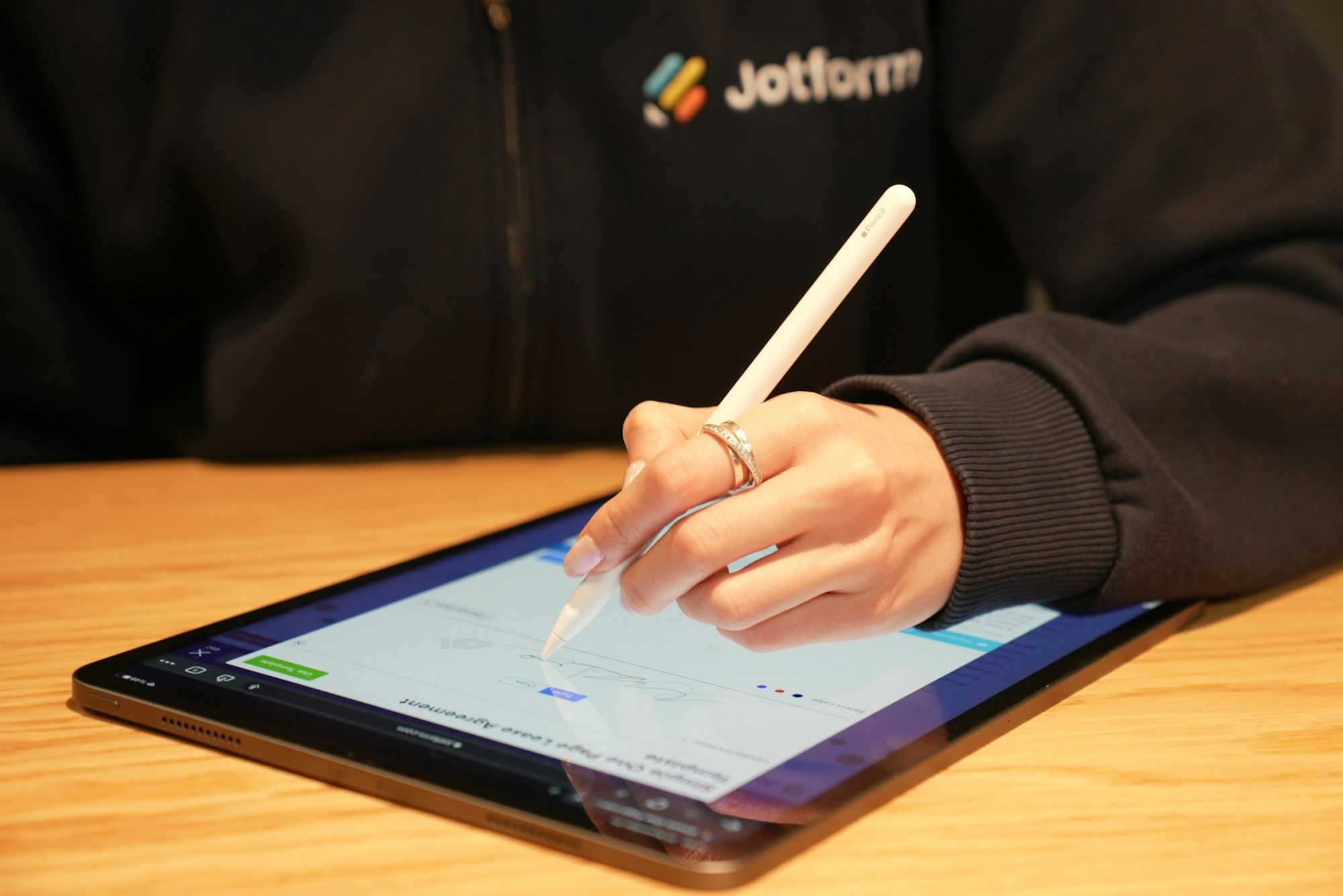 Person signing a document on a tablet screen with a stylus pen